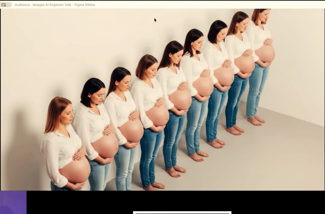 Nine pregnant women stand in a row wearing white shirts and jeans.