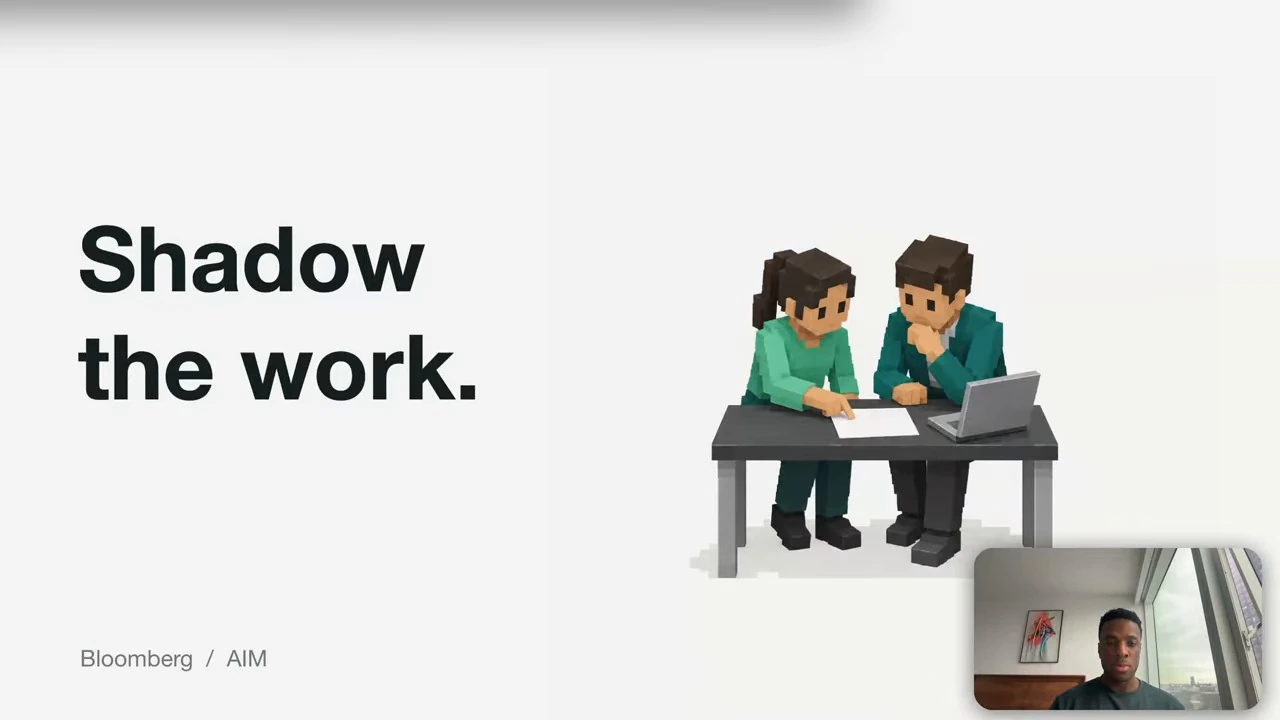 Two people review a document together at a table beside a laptop.